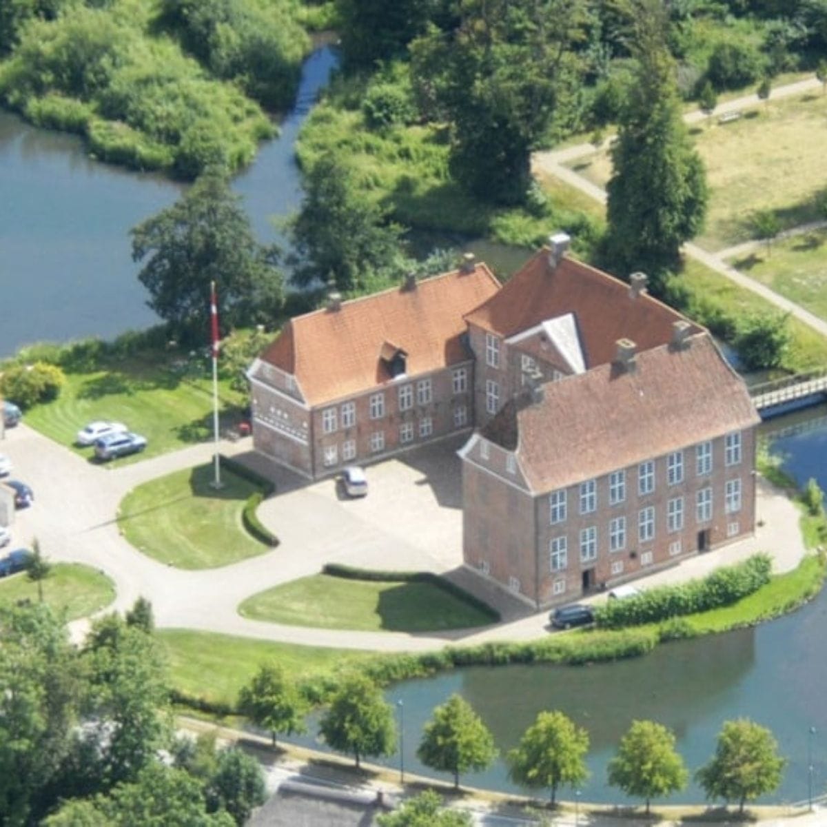 Gram Slot set fra oven med efterårssol og natur.