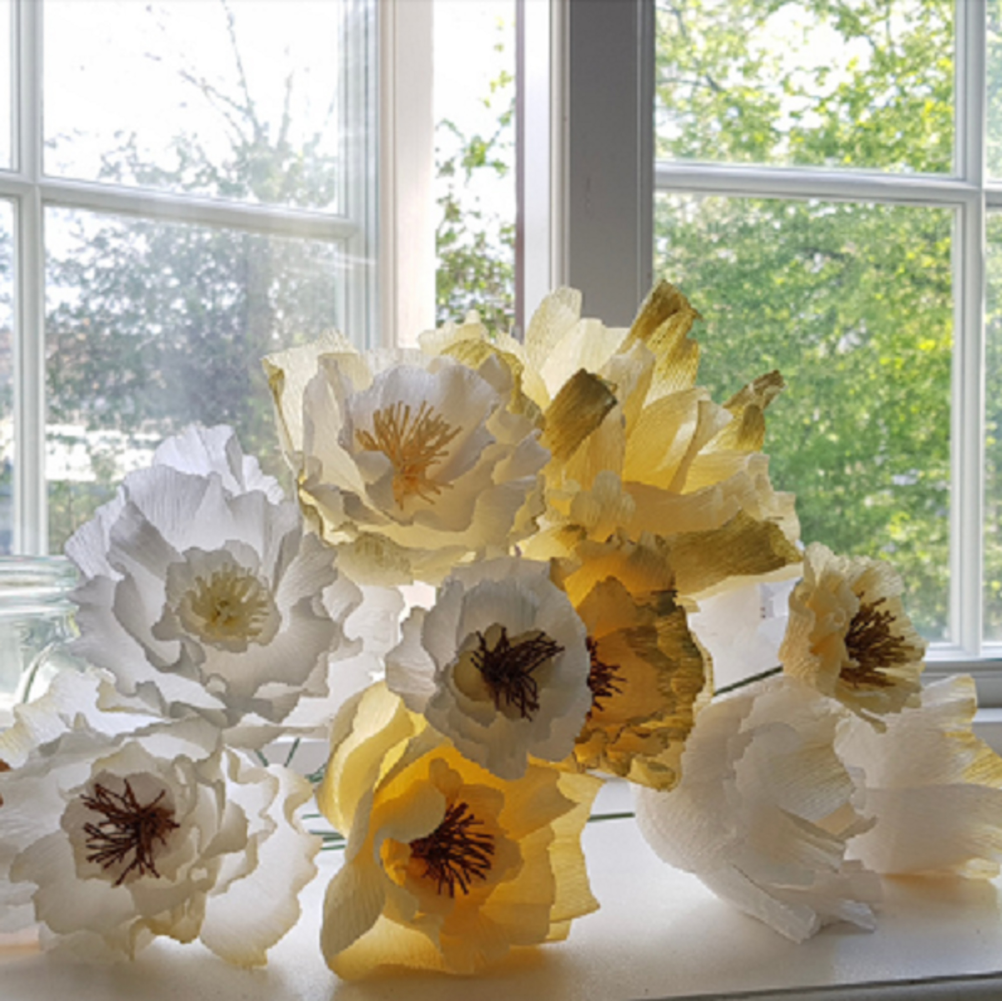 Hvide og gule papirblomster i crepe