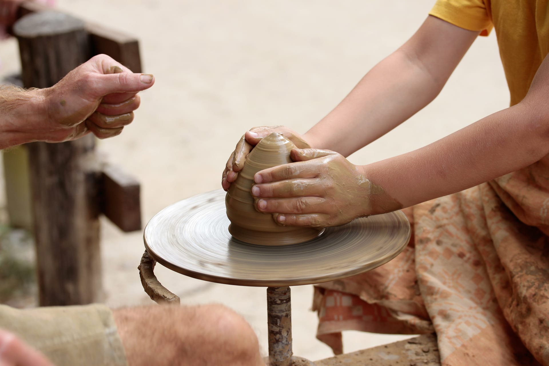 Barn former ler på drejeskive under et keramikkursus.
