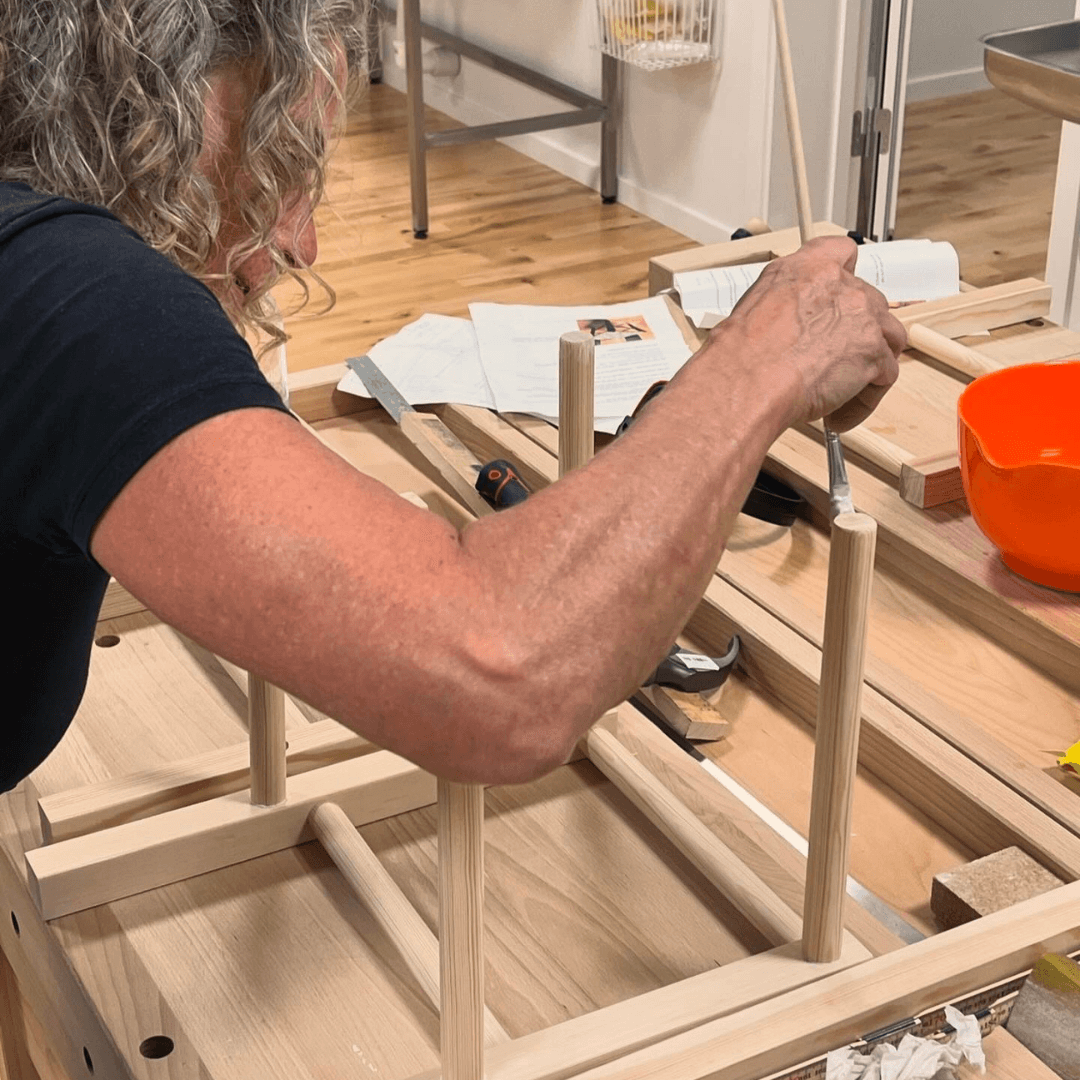 Kursist arbejder på at bygge og flette sin egen skammel