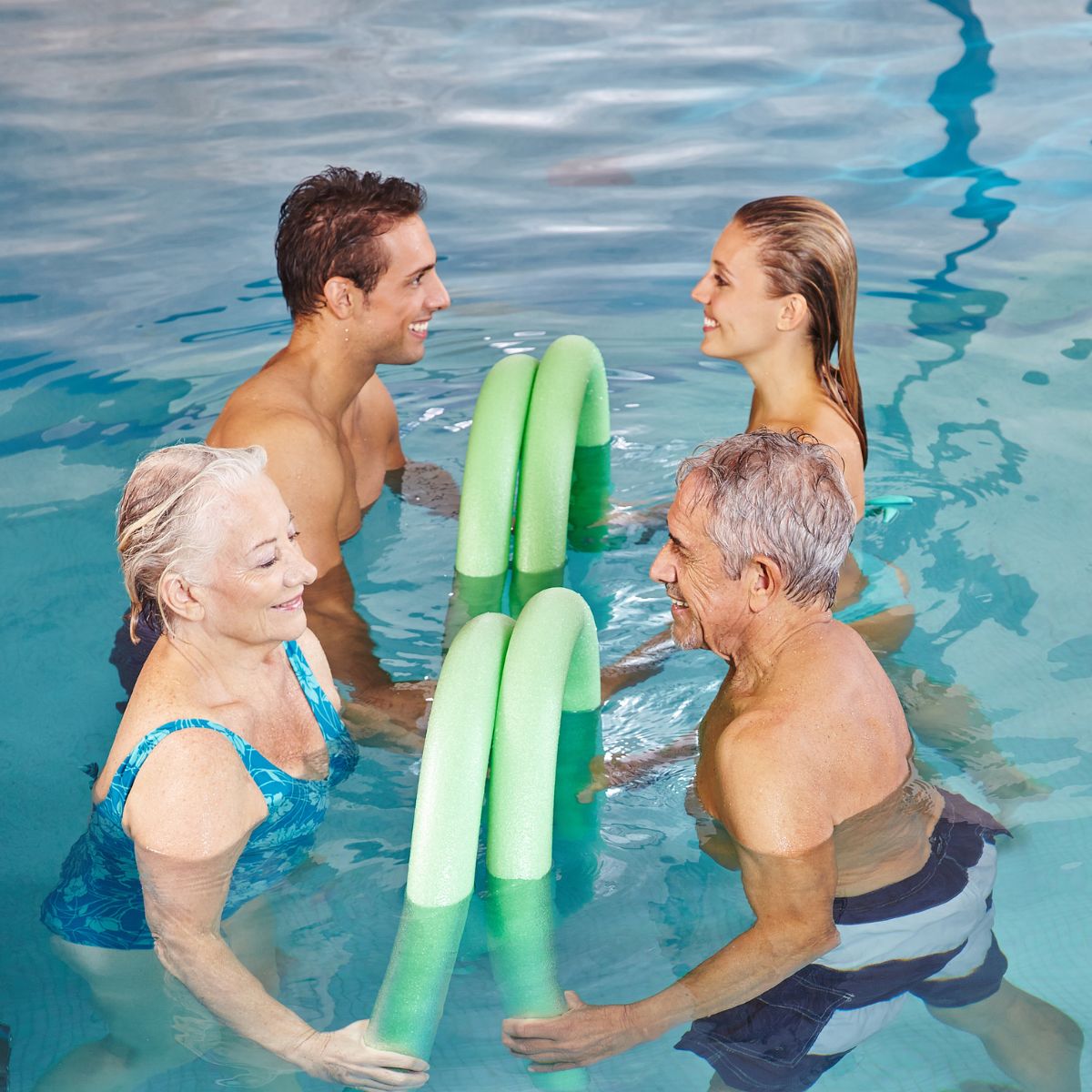 Deltagere træner roligt i varmtvandsbassinet på Herlev Hospital med fokus på at lindre smerter i ryg skuldre og nakke under vejledning af en fysioterapeut