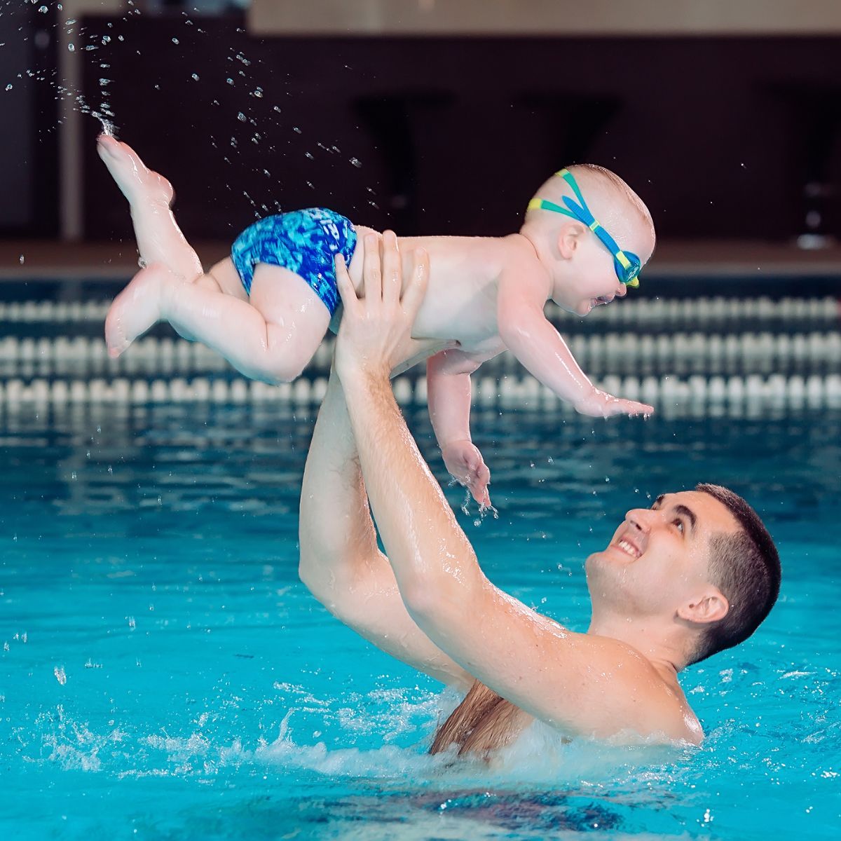 Baby/barn leger med far i vandet