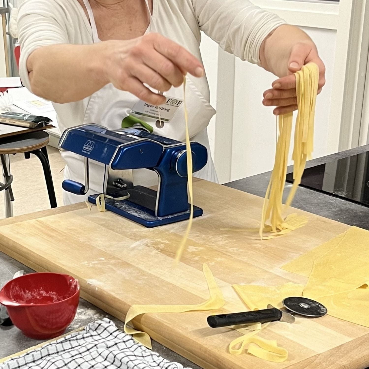 Inger harborg der laver lang italiensk æggepasta ved et bord med en pastamaskine