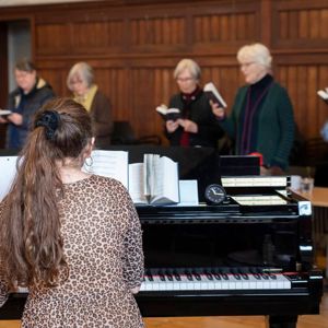 Fællessang og smørrebrød. Klaver og kursister, der synger på FOF Aftenskolen Aarhus