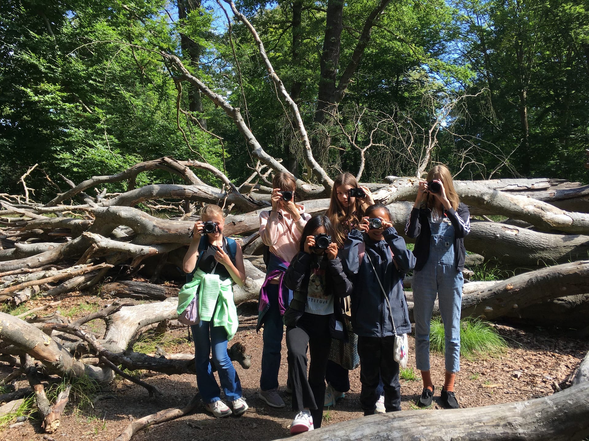 Unge deltagere fotograferer udendørs med digitalkamera på fotoskole hos FOF København og Nordsjælland