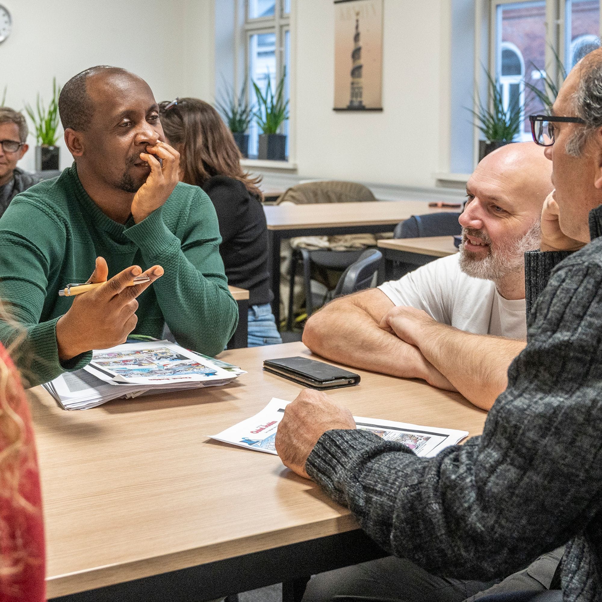 Underviser og kursister til FVU dansk med FOF Vest i Esbjerg snakker ved bordet