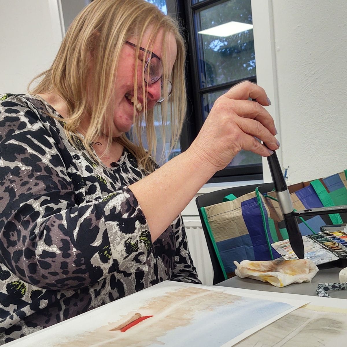 Øvet deltager maler akvarel med fokus på farver, komposition og personlig stil under guidet undervisning.
