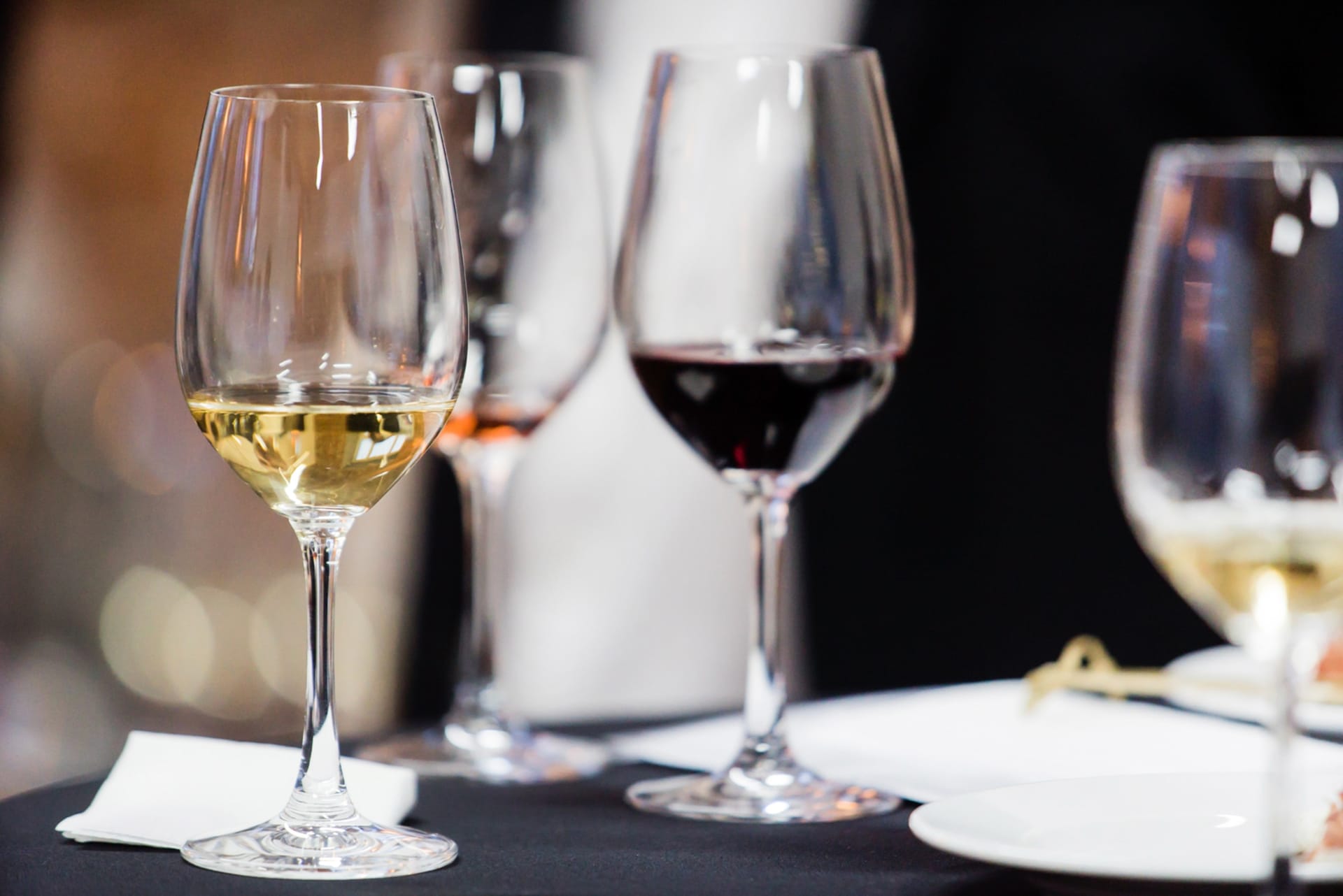 Glas med hvid, rød og rosévin på bord