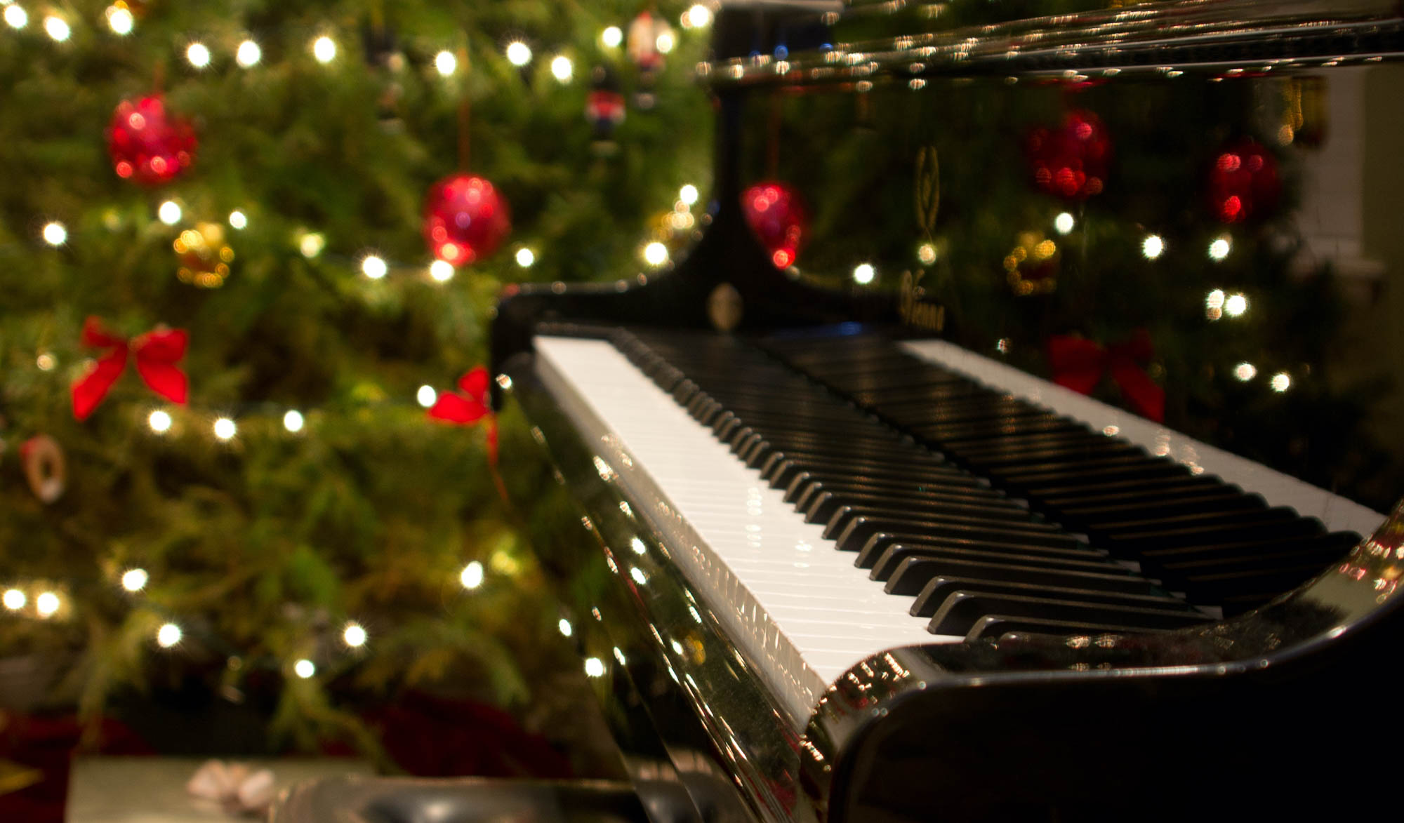 Klaver med juletræ og lyskæder på i baggrunden