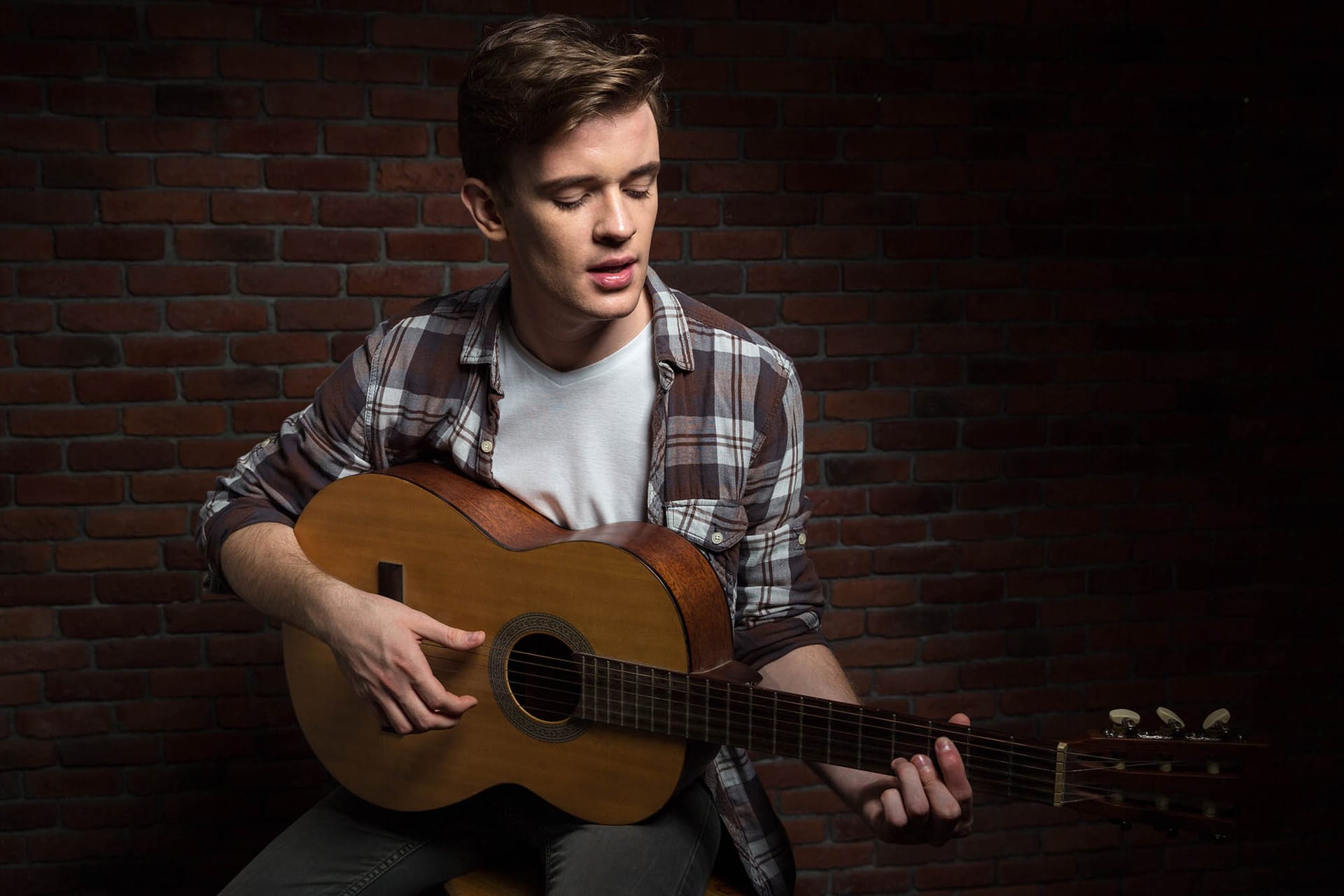 Deltager øver guitar og sang på begynderhold hos FOF København og Nordsjælland