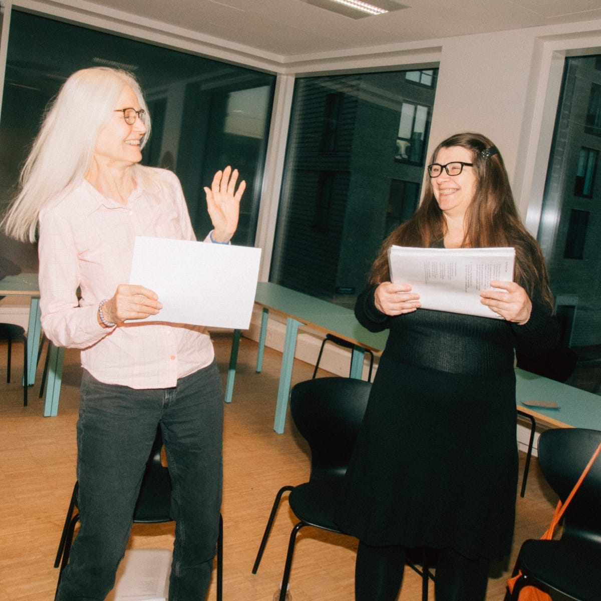 Kvinder synger sammen i et kor på aftenskolen