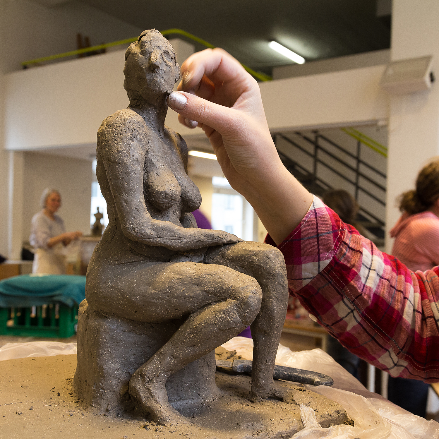 Kursist modellerer en skulptur i helfigur ud fra model