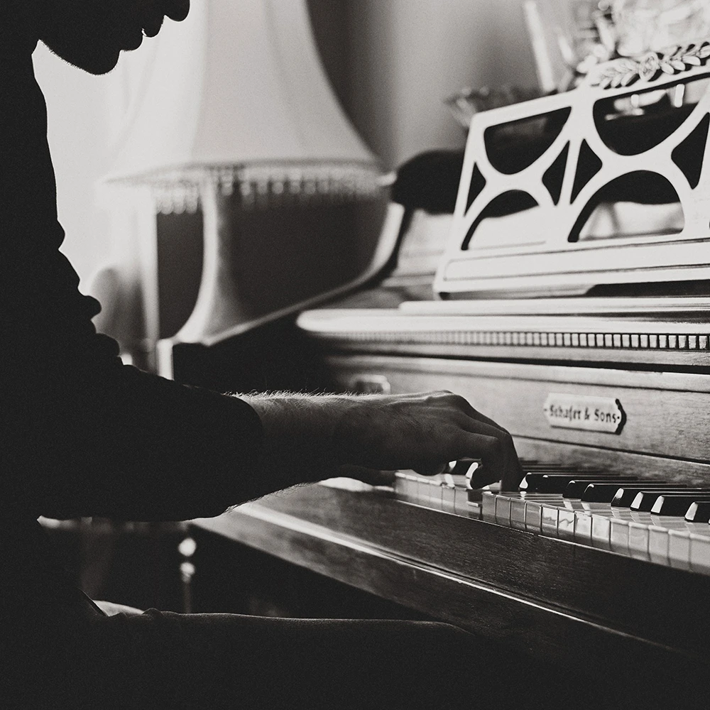 Sort hvid billede af en person som spiller klaver