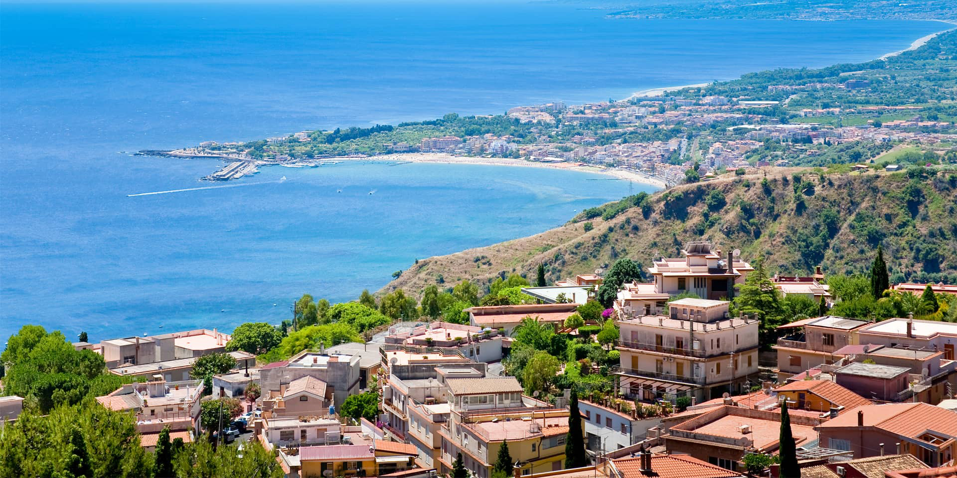 Kyst med blåt vand og huse i Italien. Lær turistitaliensk på kursus i FOF Aarhus