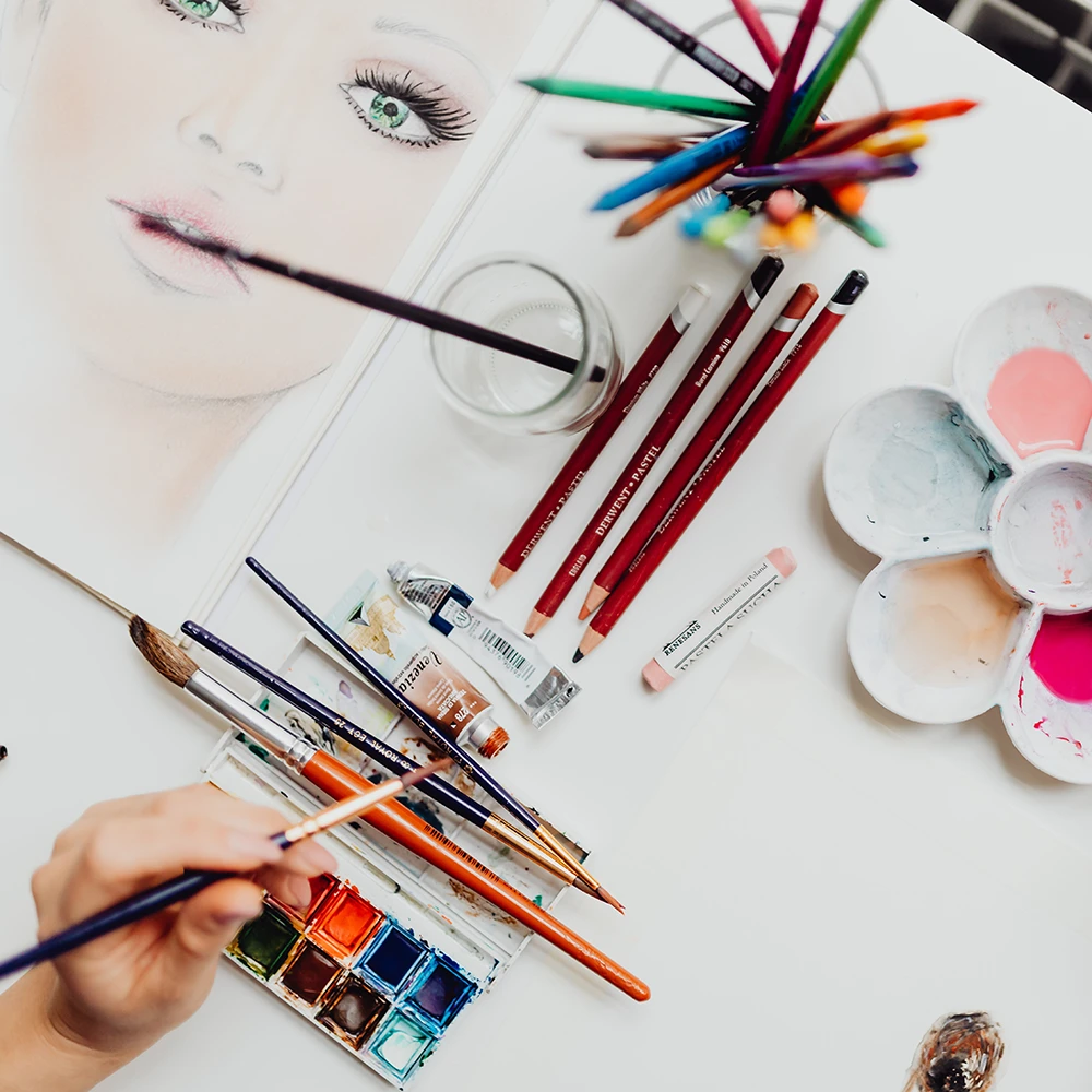 Bille af pensler, blyanter og et portræt