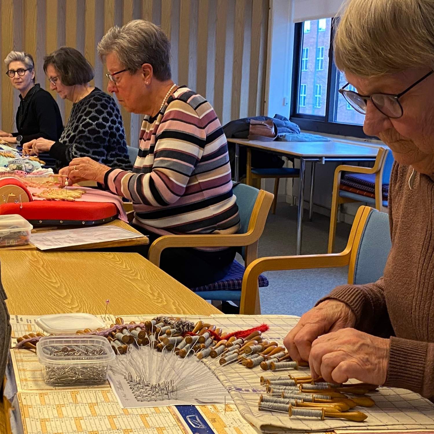 Kursister der knipler på kniplebrætter