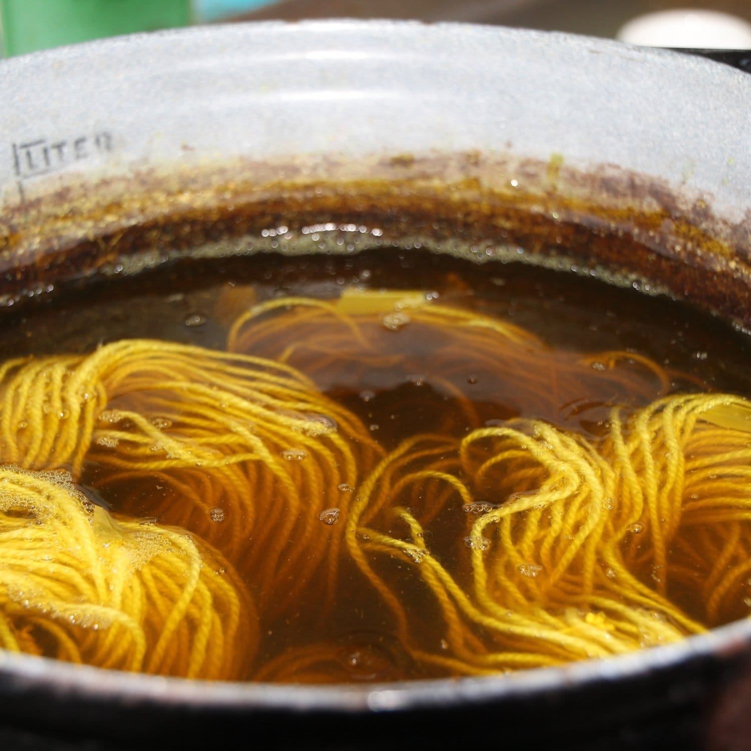 Planter og garn der farves i en gryde