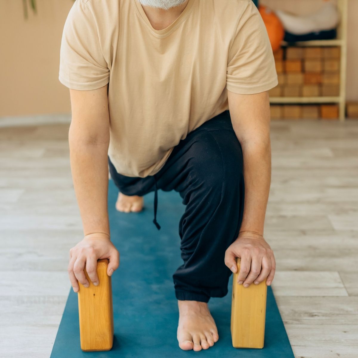 Mand udfører yogaøvelse med fokus på styrke og balance under undervisning