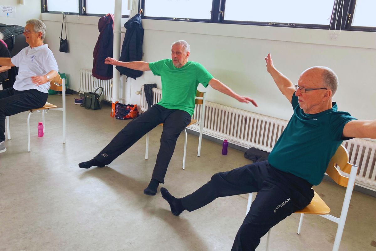 Mænd laver yoga på stole