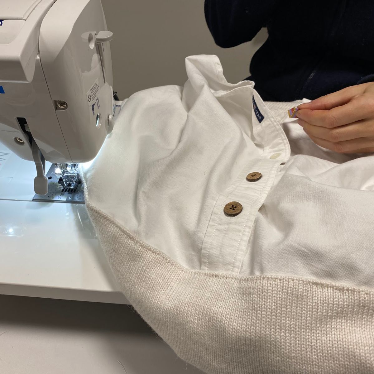 Symaskine og en hvid skjorte i proces