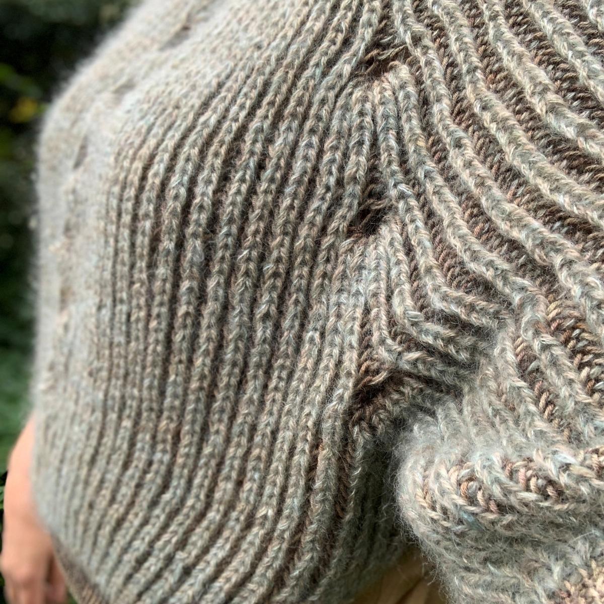 Patentstrikket sweater i tofarvet patent med markant struktur og farveskift.