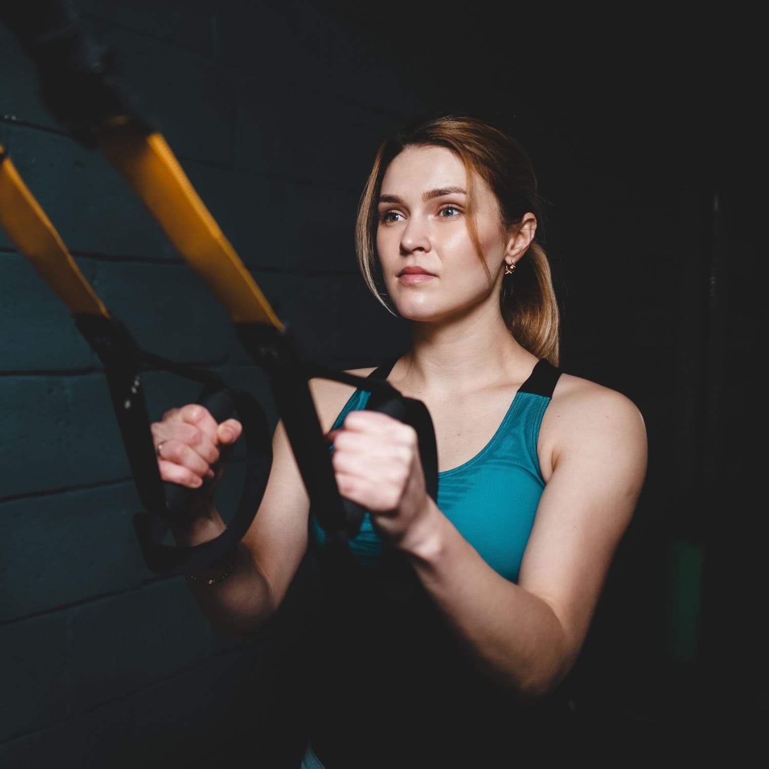 Deltager får tryg guidning i hensyntagende TRX-øvelse.