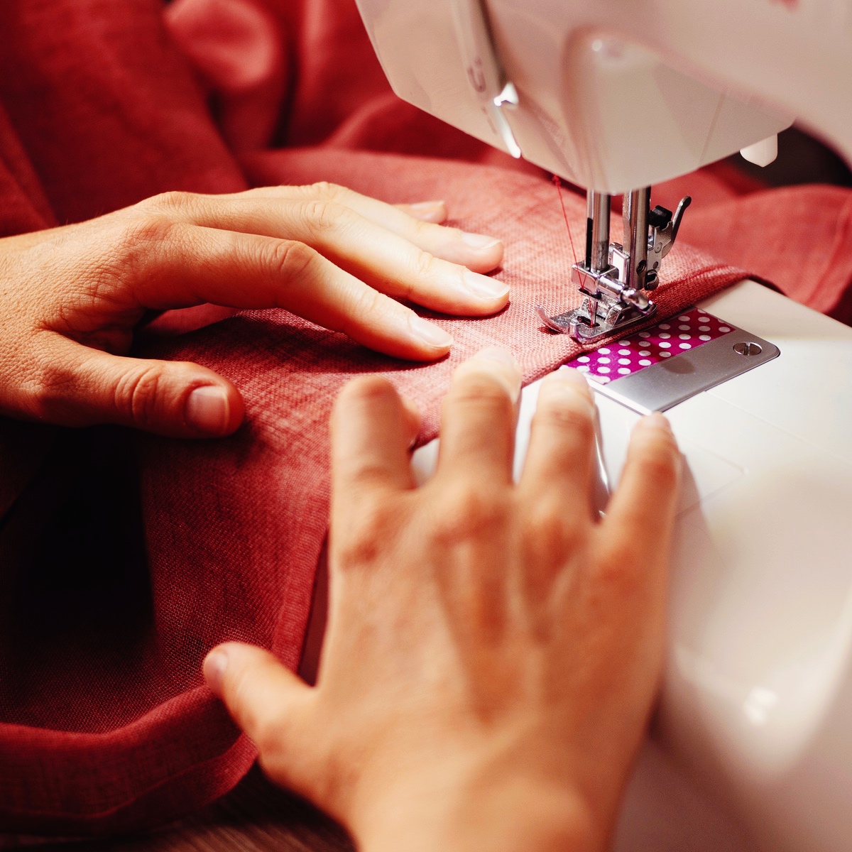 Person syr tøj ved symaskine på sykursus hos FOF.