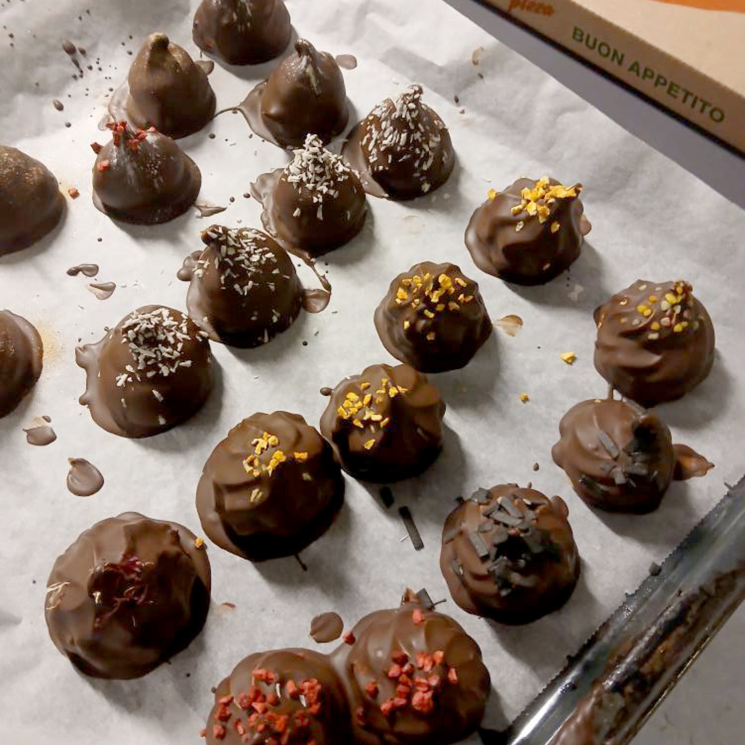 Kursist der er ved at sætte en bageplade med makronbunde med flødebolle fyld ind i en ovn