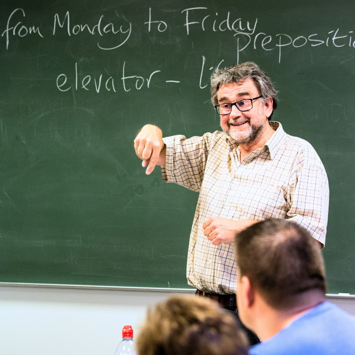 underviser står foran tavle og underviser