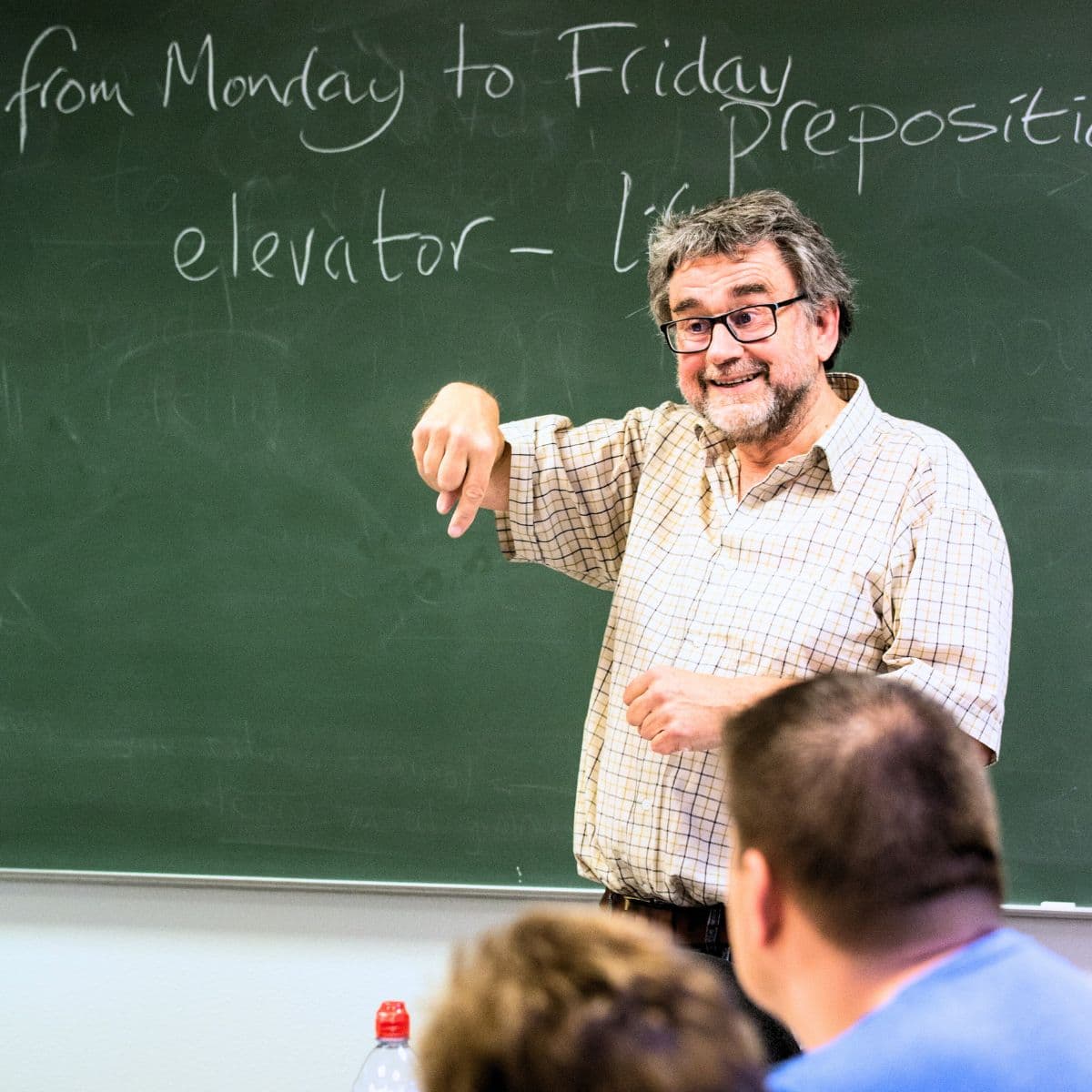 underviser står foran tavle og underviser