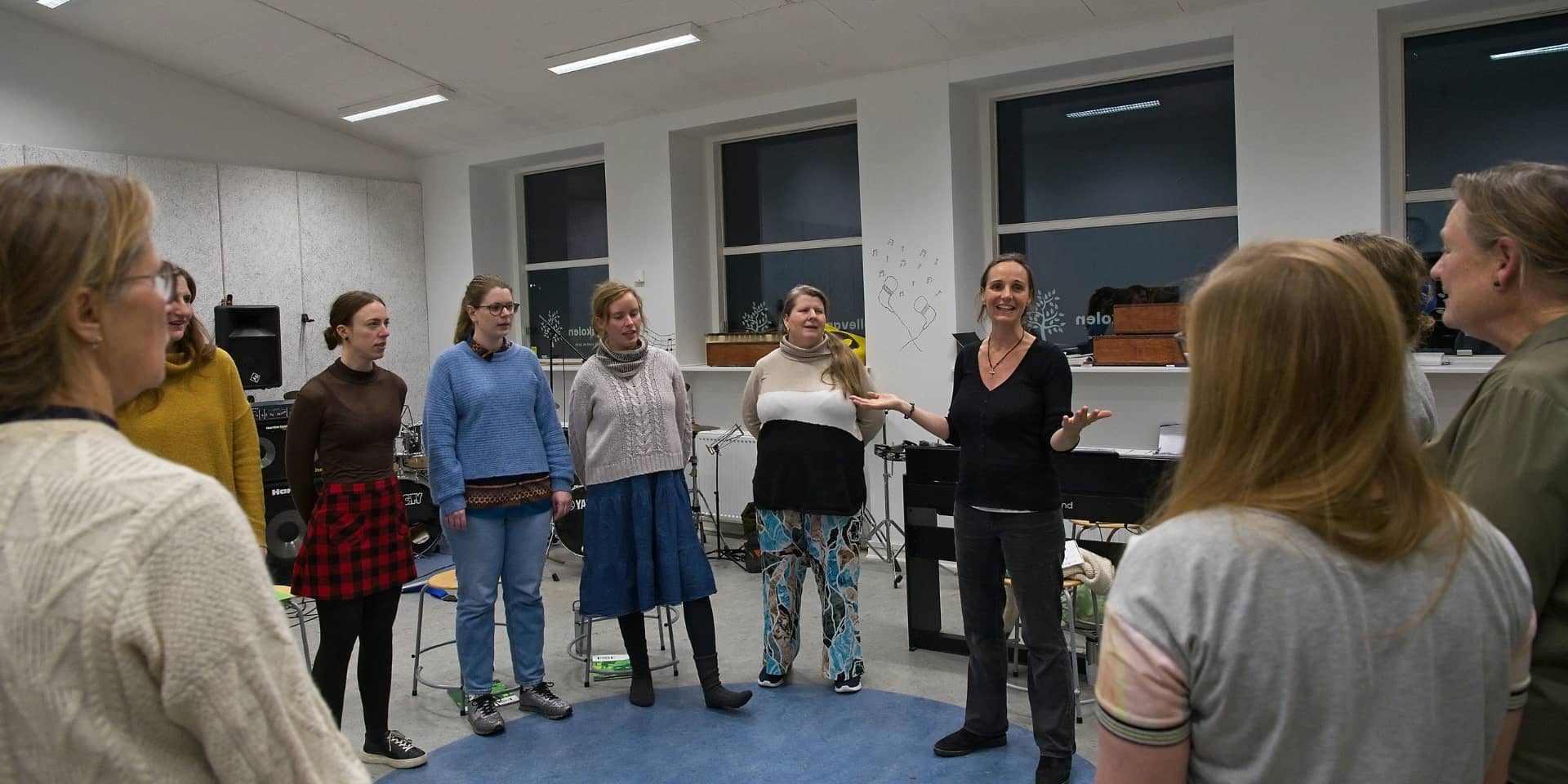 En korleder og kordeltagere på et kor med titlen Happy Hearts i FOF Aarhus.