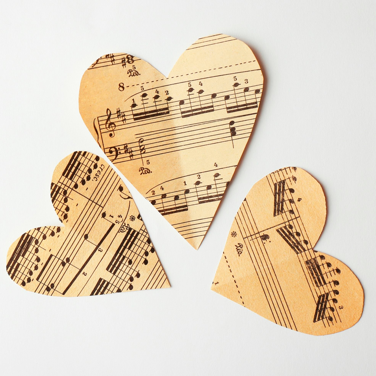 Tre papirhjerter klippet af nodeark. Sanghjerterne Fællessang for mennesker med demens hos FOF København og Nordsjælland