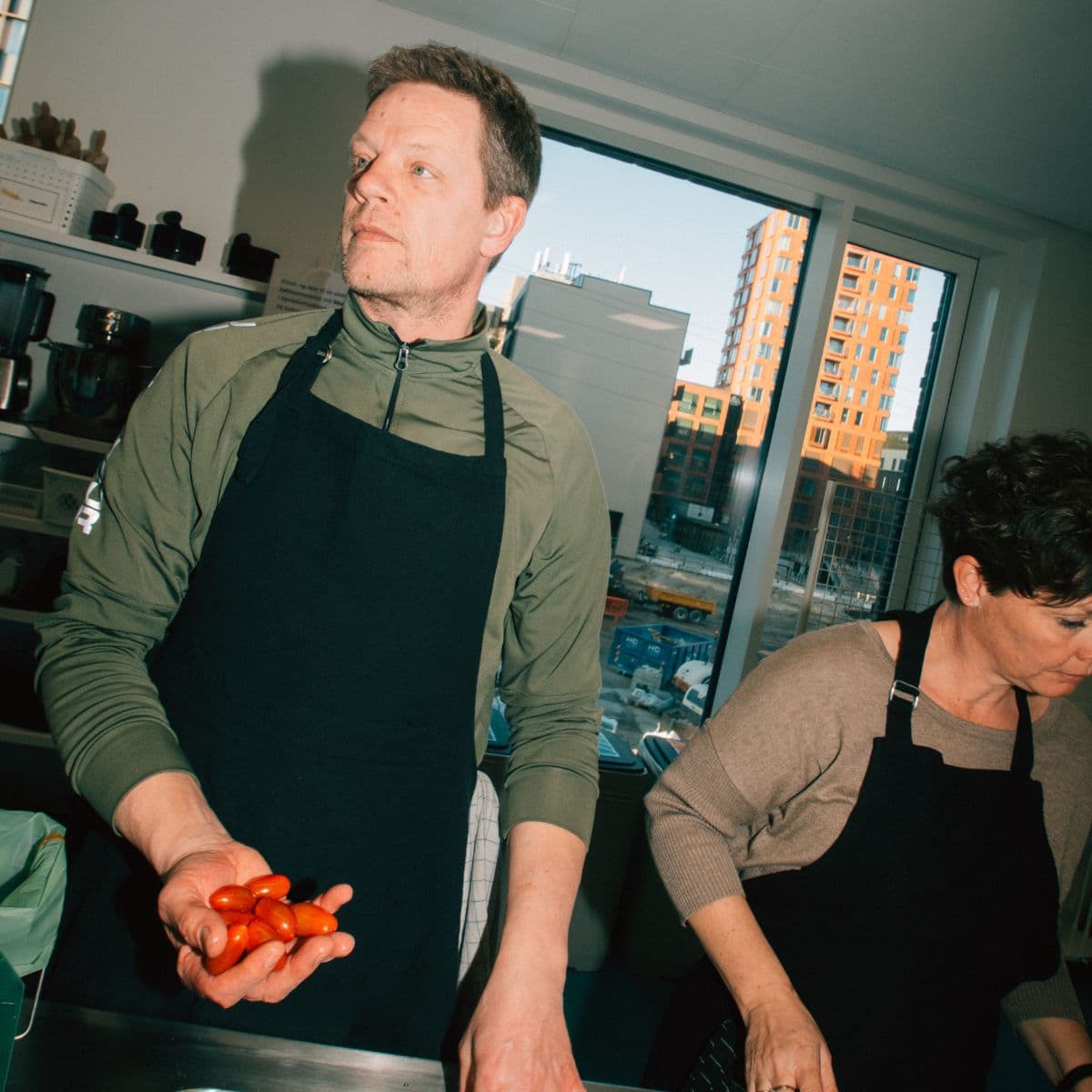 mand med forklæde laver mad