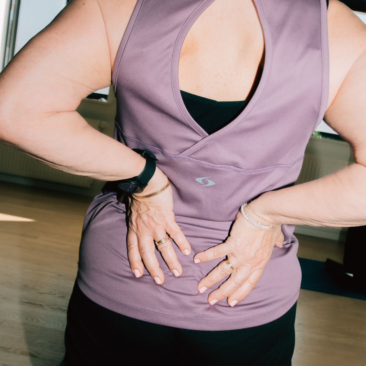 Kvinde der tager sig til ryggen