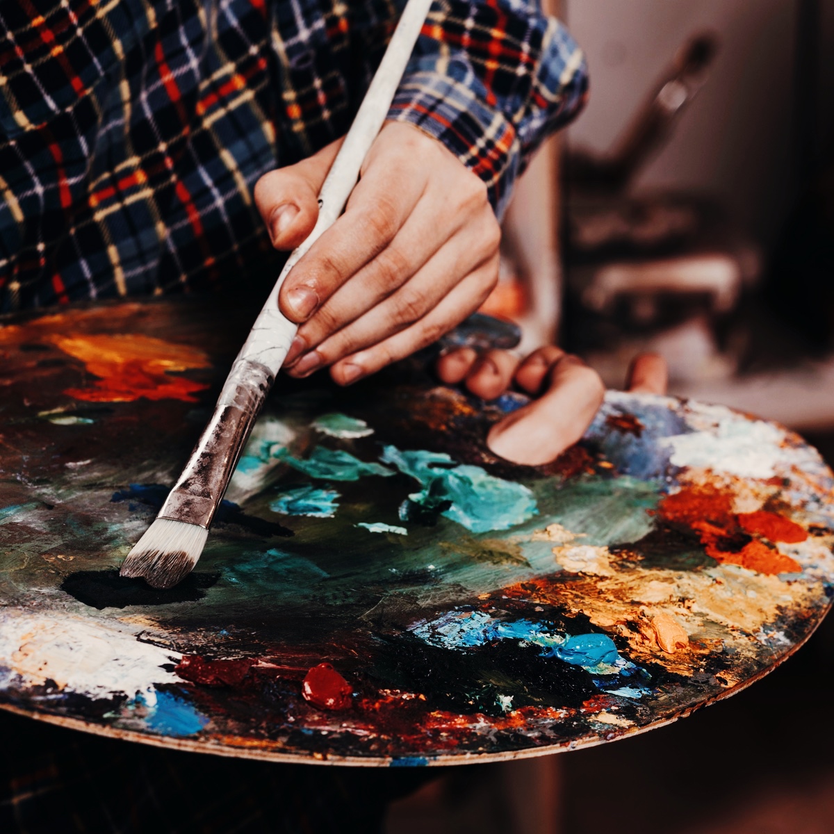 Deltager maler med akrylfarver på kursus i akrylmaleri hos FOF Aalborg.