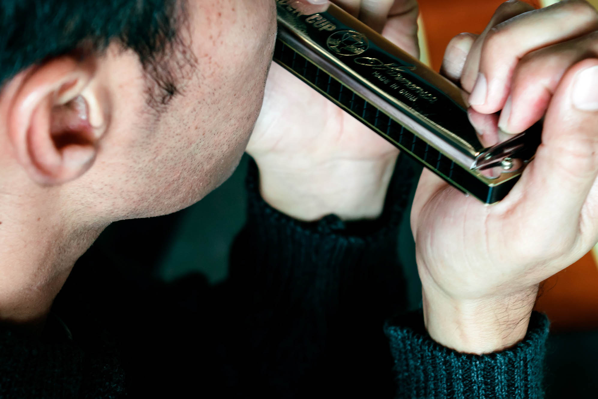 Deltager spiller mundharmonika på bluesharpe-kursus hos FOF København og Nordsjælland