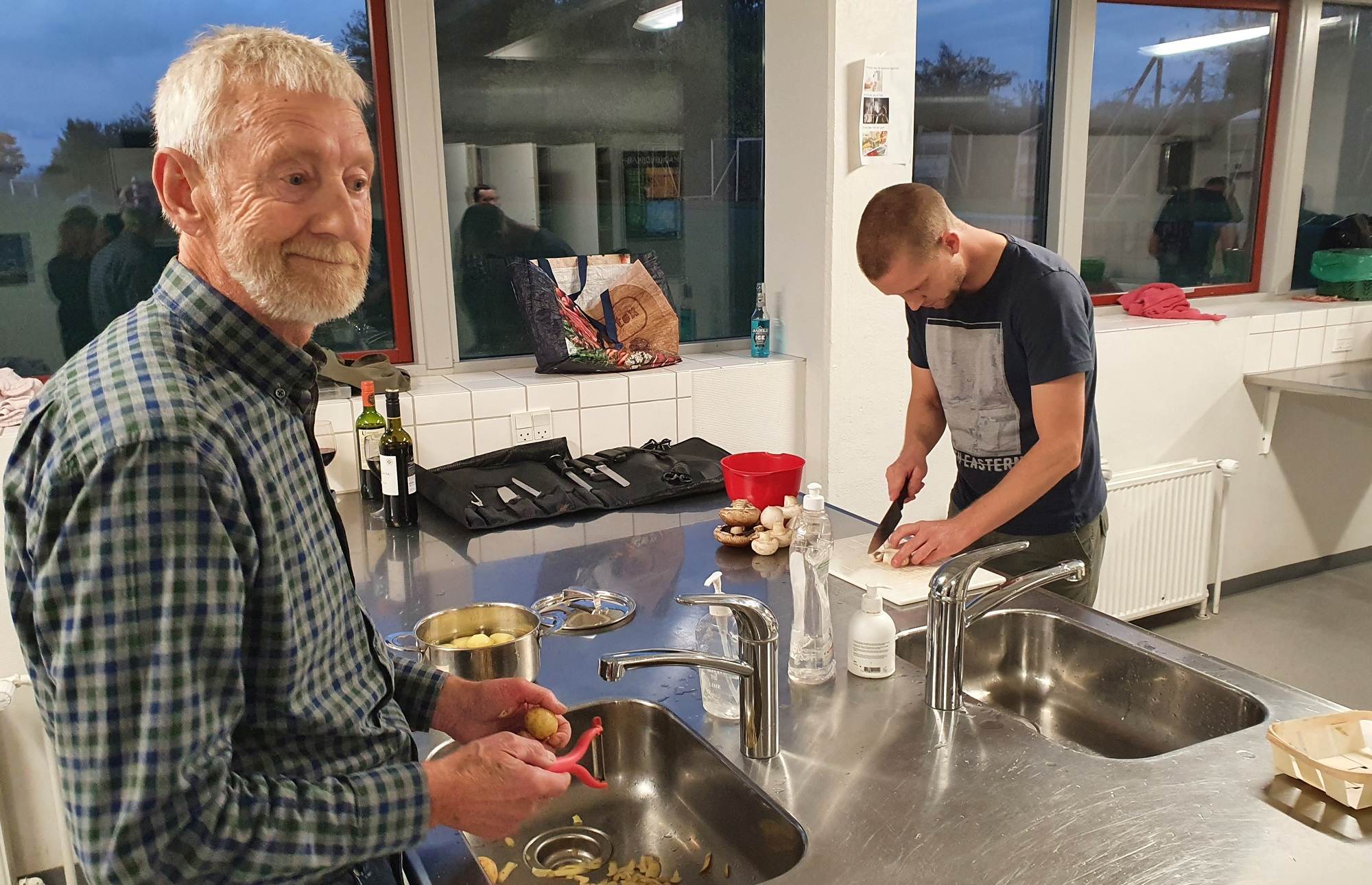 Ung og ældre mand laver mad i skolekøkken