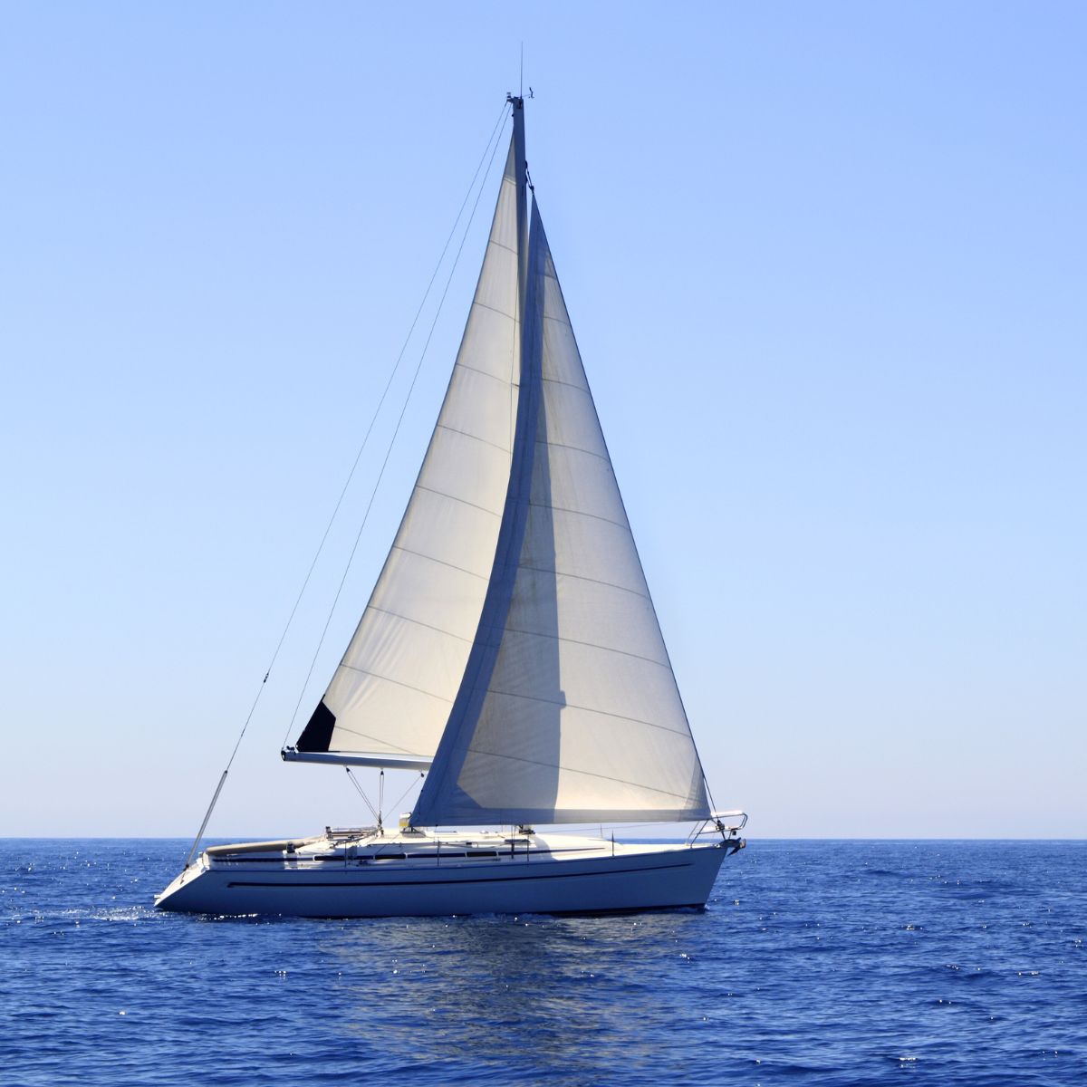 Sejlskib i blåt hav med blå himmel.