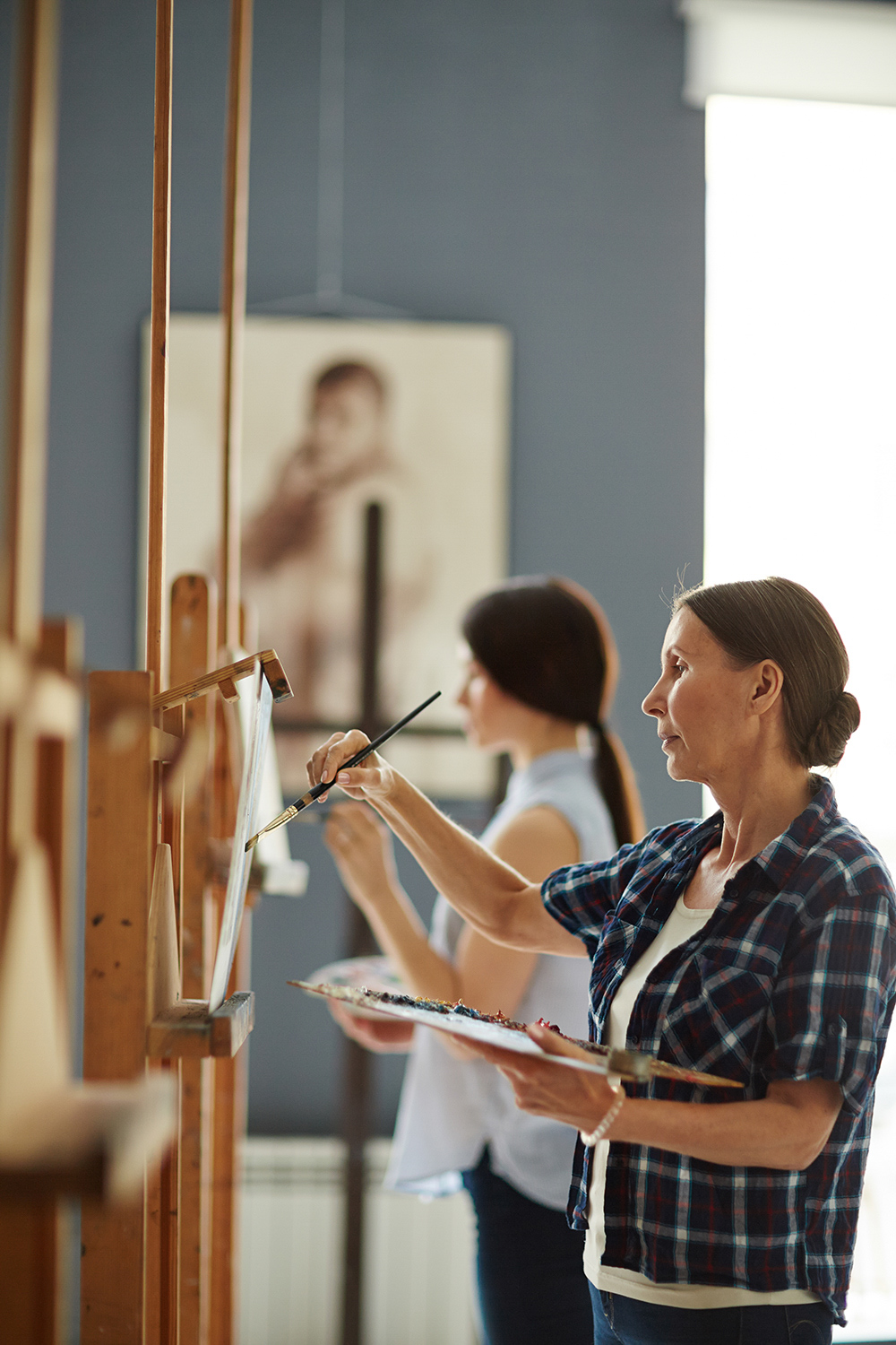 Deltager maler portræt med pensel og farver