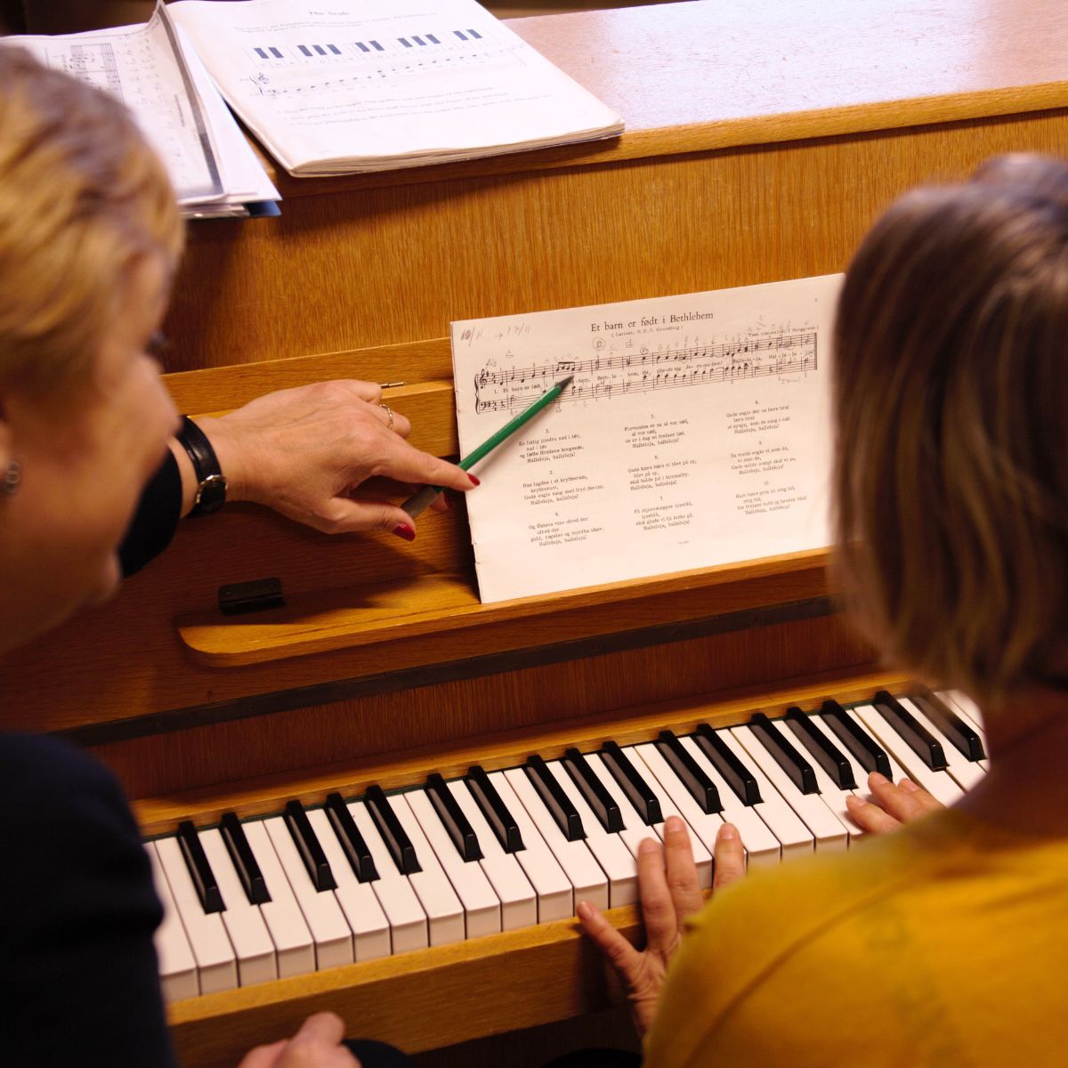 Person spiller klaver under musikundervisning hos FOF.