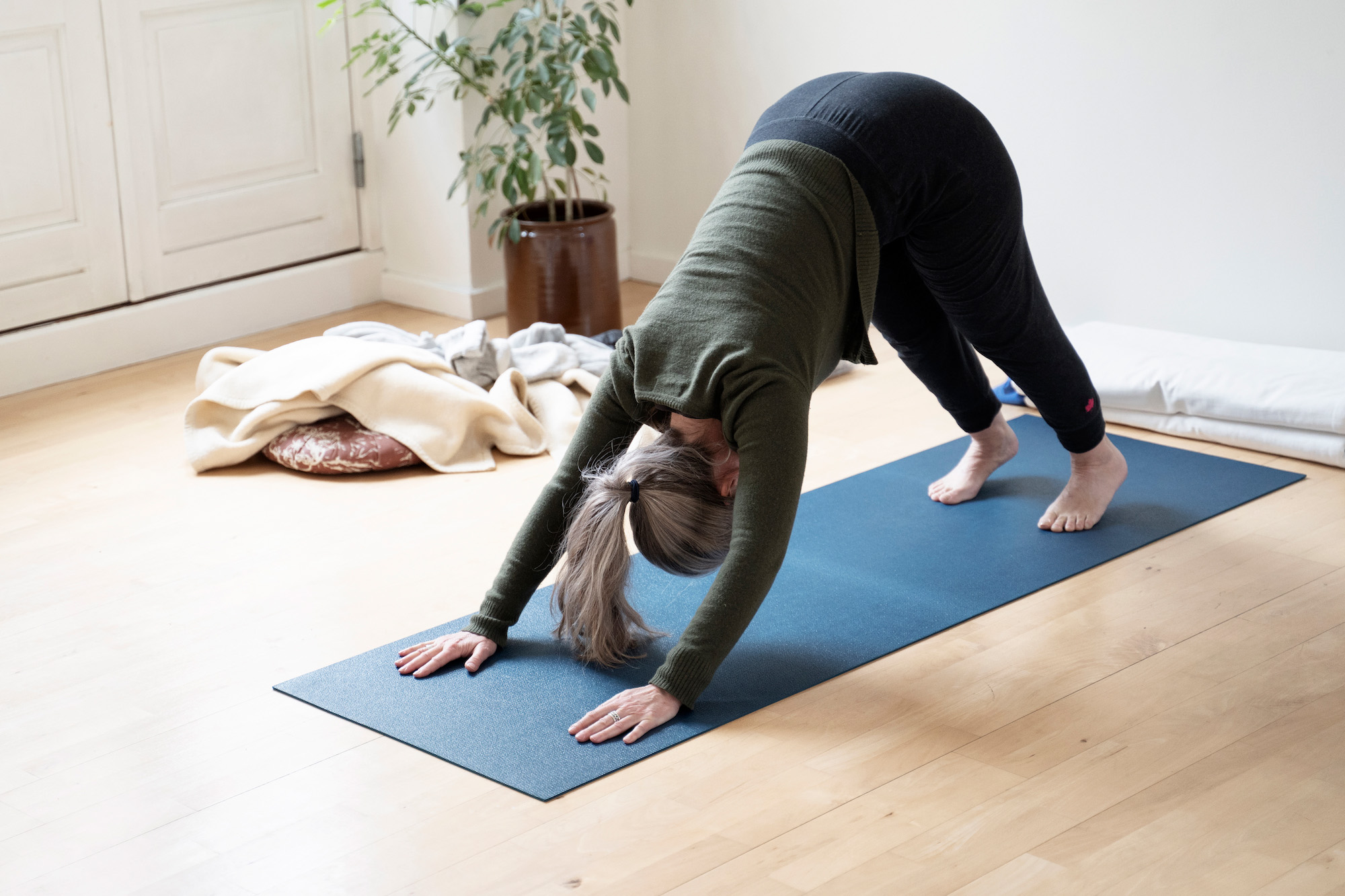 Kvinde i yogastilling på måtte