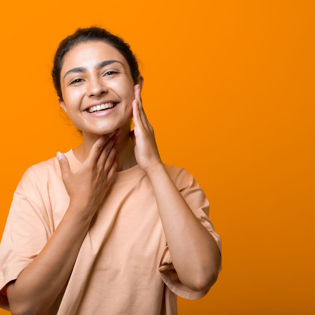 Kvinde laver ansigtsyoga med fokus på kæbe og kindmuskler.