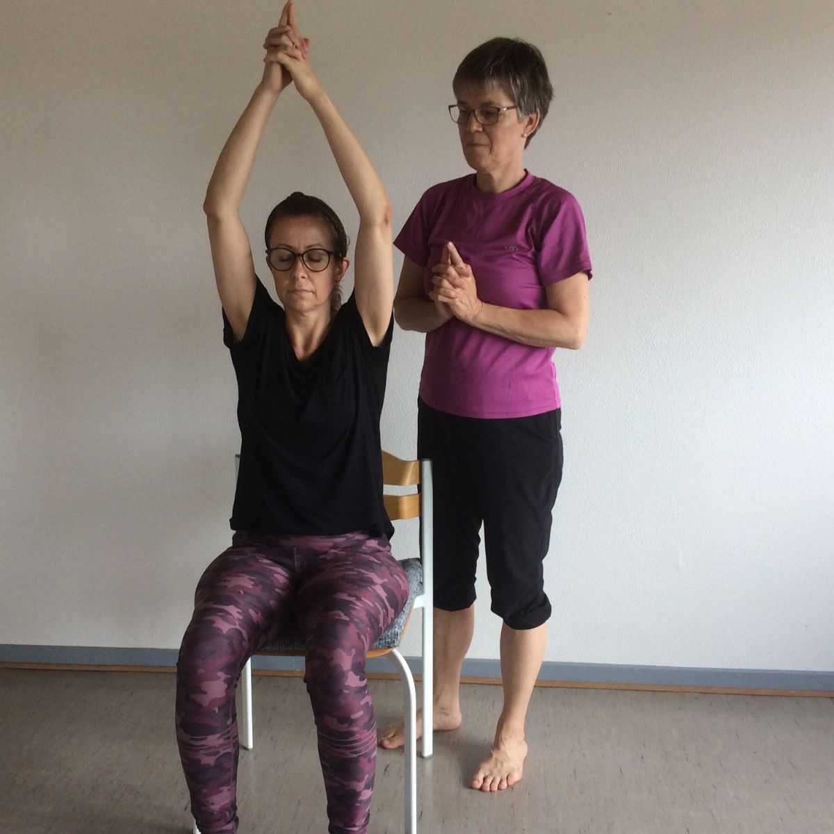 Kursist laver yogaøvelse med underviser