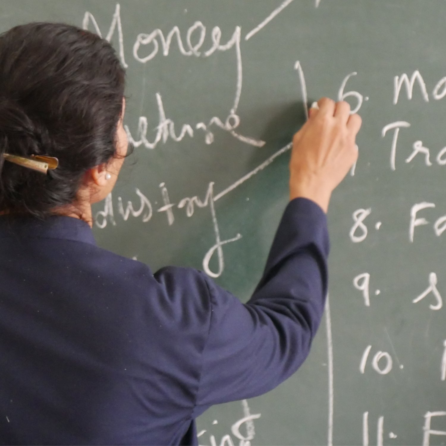 Kursist der skriver engelsk grammatik på en grøn tavle med hvid kridt