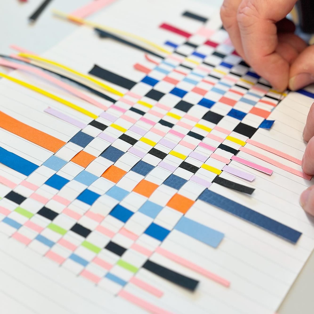 børn væver farvet papir i mønster