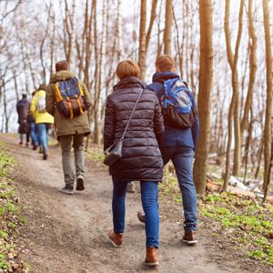Deltagere går gennem skoven med rygsække med fokus på fællesskab.