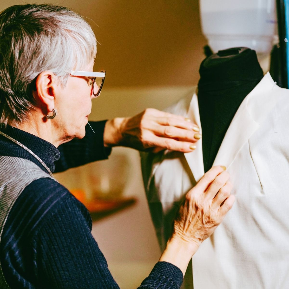 Kvinde sætter nåle i et syprojekt på gine.