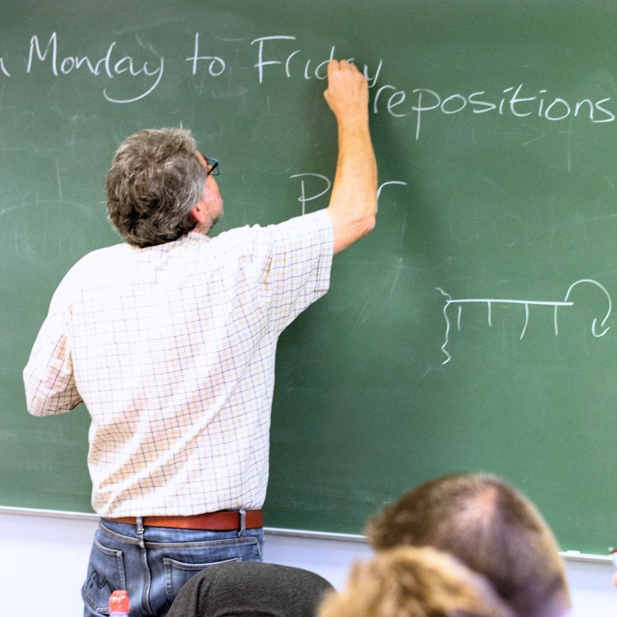 FOF underviser i engelsk a2 der skriver på tavlen