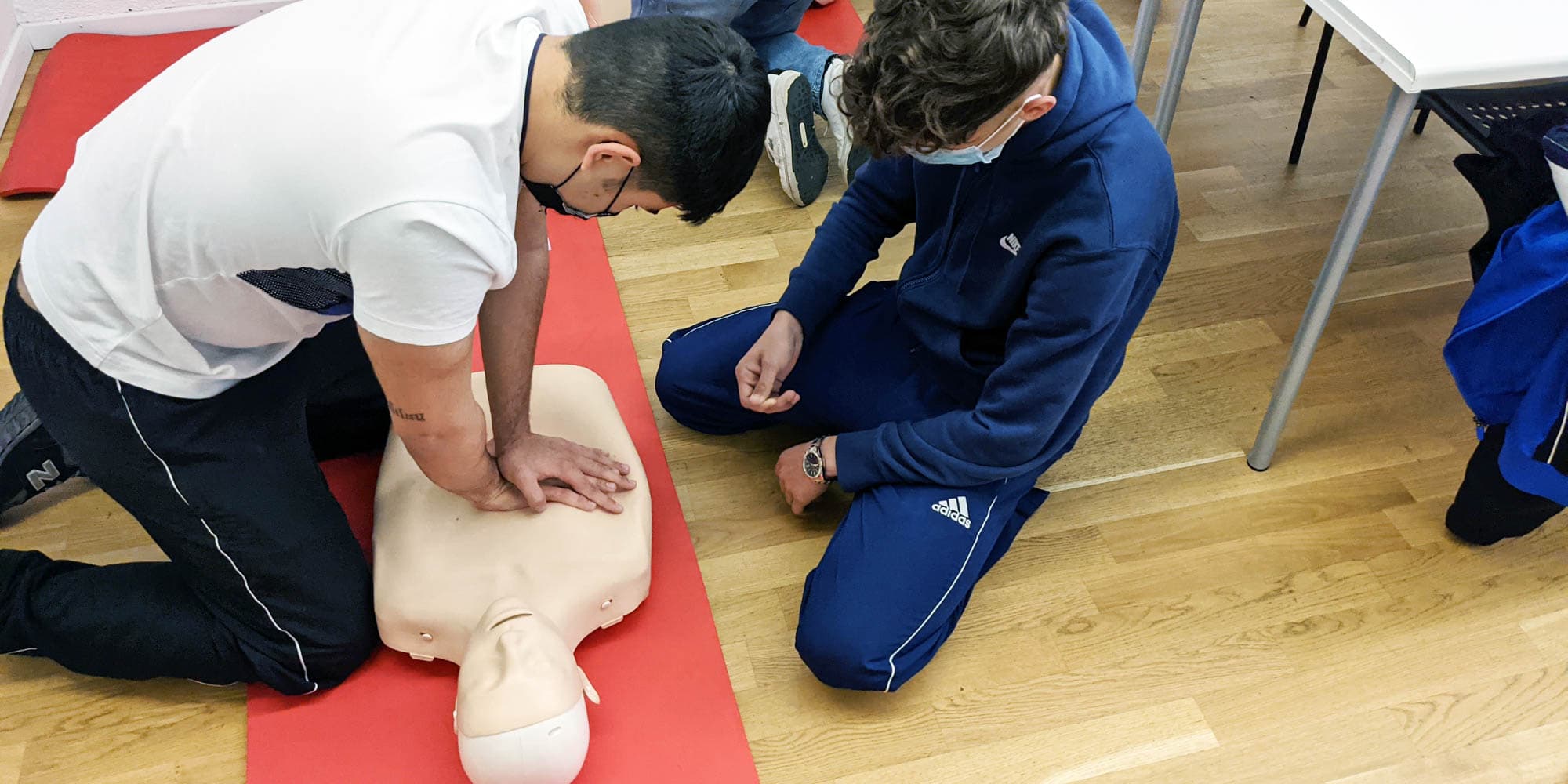 Kursister øver HLR og førstehjælp på et kørekortkursus hos FOF