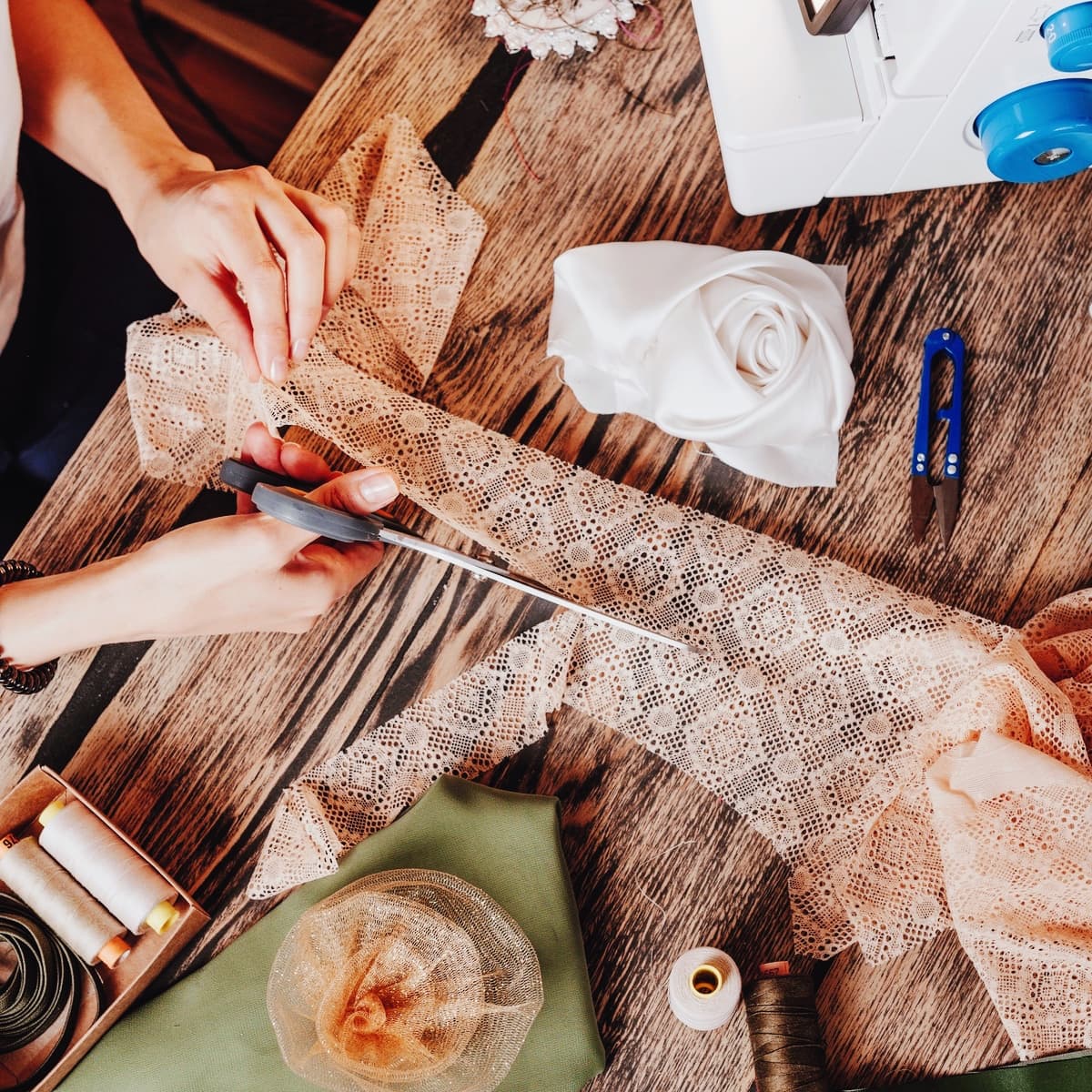 Hænder klipper genbrugt tekstil under kreativt upcycling-kursus.